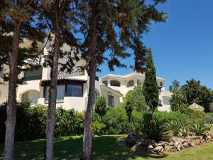 马贝拉Vista Hermosa Marbella的一座大白色房子,前方有树木