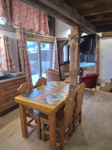 蒙查往Chalet La Plagne jacuzzi vue top的客厅配有一张木桌和椅子