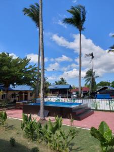 珍南海滩Collection O 90622 Sehijau Cenang的一个带游泳池和棕榈树的度假村