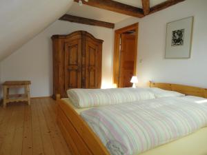 穆劳林登霍夫酒店的一间卧室配有一张床和一个木制橱柜