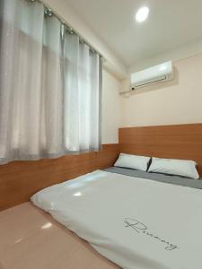 龍潭十六石遛民宿的一间卧室设有一张床和一个窗口