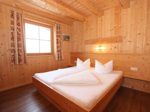 JunsChalet Chalet Elisabeth by Interhome的木制客房内的一间卧室,配有一张床