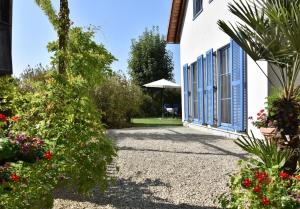 Ferienhäuser Bellana的鲜花花园和蓝色百叶窗度假屋