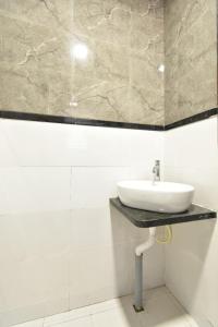 索拉普Hotel Ashirwad, Solapur的墙上的白色浴室设有水槽