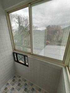 龍潭十六石遛民宿 桃園市民宿127號的浴室设有窗户和瓷砖淋浴。