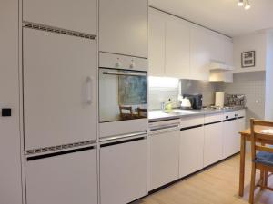 UnterseenApartment Bieri-Haus by Interhome的白色的厨房配有白色的橱柜和桌子