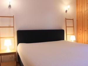 威拉尔-苏-罗伦Apartment Athena 6 by Interhome的卧室配有带两盏灯的白色床