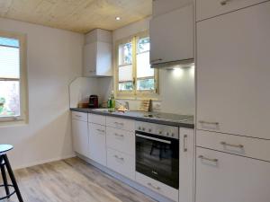 因特拉肯Holiday Home Chalet Dori by Interhome的厨房配有白色橱柜和炉灶烤箱。