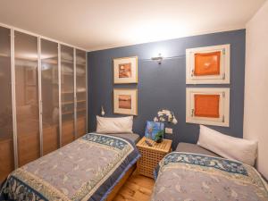 席尔瓦普拉纳Apartment Chesa Polaschin 4 - Silvaplana by Interhome的蓝色墙壁客房的两张床