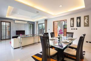 查龙Villa Piyada的用餐室以及带桌椅的厨房。