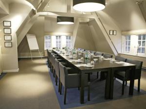 霍尔滕品质住宿酒店的长长的用餐室配有长桌子和椅子
