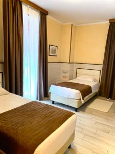 莱诺Hotel Lenotel的酒店客房设有两张床和窗户。