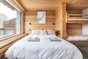 梅杰夫Cocon au pied des pistes de ski du Mont-d'Arbois的卧室配有一张白色大床,位于木墙内