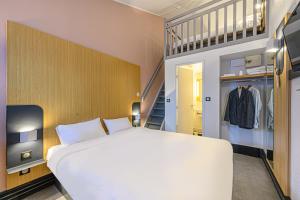 瓦讷B&B HOTEL Vannes Est Golfe du Morbihan的卧室设有一张白色大床和楼梯。