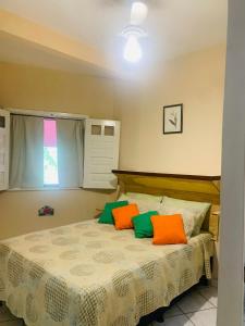 伦索伊斯Vila das Estrelas - Guesthouse的一间卧室配有带橙色和绿色枕头的床