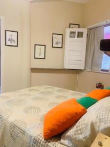 伦索伊斯Vila das Estrelas - Guesthouse的一间卧室配有一张带橙色枕头的床