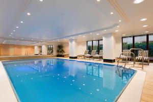 富尔达玛丽蒂姆富尔达酒店的酒店的大型游泳池配有桌椅