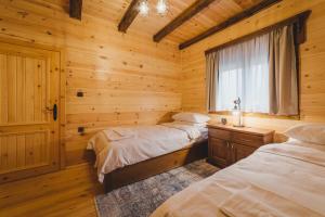 莫伊科瓦茨Eco Village & Chalets Green Heaven的小木屋内一间卧室,配有两张床