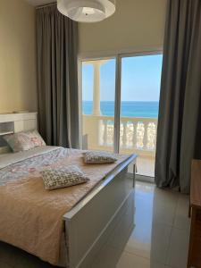 拉斯阿尔卡麦Royal Breeze view的一间卧室设有一张床,享有海景