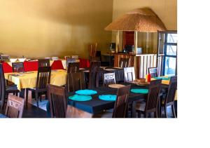 奥奇瓦龙戈MSC Hotel Otjiwarongo的一间配备有桌椅及蓝色座椅的餐厅