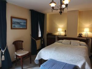 哈维亚瑞斯可酒店的一间卧室配有一张大床和一把椅子