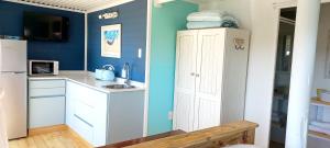 兰格班The Blue Room的厨房设有蓝色的墙壁和白色的橱柜。