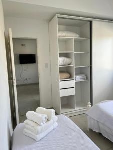 贝纳多图埃托Apart hotel Magda的卧室配有白色毛巾,位于床上
