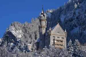 施万高AMERON Neuschwanstein Alpsee Resort & Spa的雪覆盖的山中的一个城堡