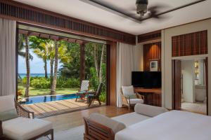 马埃岛Anantara Maia Seychelles Villas的一间卧室配有一张床,享有游泳池的景色