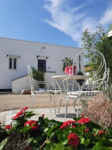 格拉维纳普利亚Masseria Santa Maria的花园内提供两把白色椅子和一张桌子