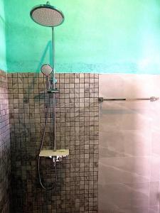 乌纳瓦图纳H&C Heaven Beach Hotel的带淋浴的浴室(带瓷砖墙)