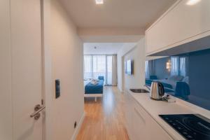 巴统Orbi City Sea View的厨房以及带蓝色沙发的起居室。
