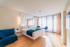 巴统Orbi City Sea View的一间卧室配有一张床和一张蓝色的沙发