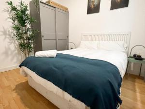 马德里La Ronda de Segovia的一间卧室配有一张带蓝色毯子的床
