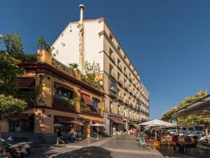 马德里La Ronda de Segovia的一条街道,有高高的建筑,外面有人在