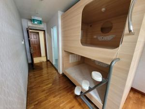 新加坡Wink at Upper Cross Street的一间小房间,走廊上设有双层床