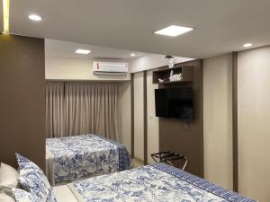 皮帕Pipa's Bay - Flats para temporada的客房设有两张床和一台平面电视。
