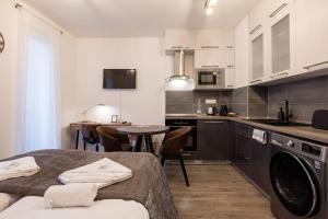布达佩斯Central Sphere Apartment的厨房配有白色橱柜和桌椅