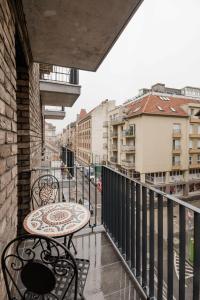 布达佩斯Central Sphere Apartment的阳台的天井配有桌椅