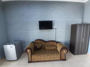 罗威那普拉布套房酒店的墙上配有电视的沙发