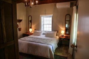 西萨默塞特San Gabriel Homestead的一间卧室配有一张带白色床单的床和一扇窗户。