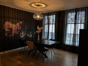 吕伐登Appartement centrum Leeuwarden的一间带桌椅和吊灯的用餐室