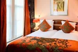 阿姆斯特丹大使酒店的酒店客房设有两张床和窗户。