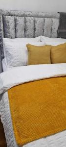 卢顿1 bed studio的一张配有黄色和白色床单和枕头的床