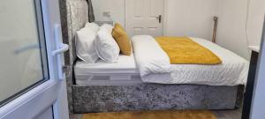 卢顿1 bed studio的一间卧室配有带白色和金色枕头的床