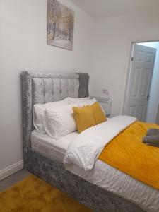 卢顿1 bed studio的卧室内的一张带白色和黄色枕头的床