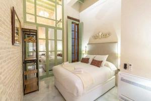 塞维利亚Judería de Sevilla I Luxury Apartments的卧室设有一张白色大床和一扇窗户。