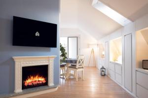 米兰Sant’Andrea Penthouse by Montenapoleone Living的客厅设有壁炉和墙上的电视