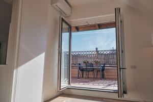 米兰Sant’Andrea Penthouse by Montenapoleone Living的滑动玻璃门通向带桌子的阳台