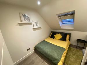 TotteridgeCosy North London 2 Bed Apartment in Woodside Park- Close to Station and Central London的一间小卧室,配有床和窗户